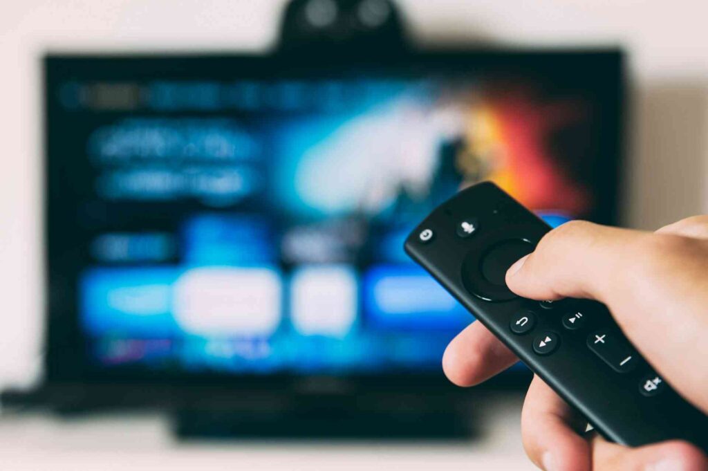 A person pressing a button on a remote for the tv.