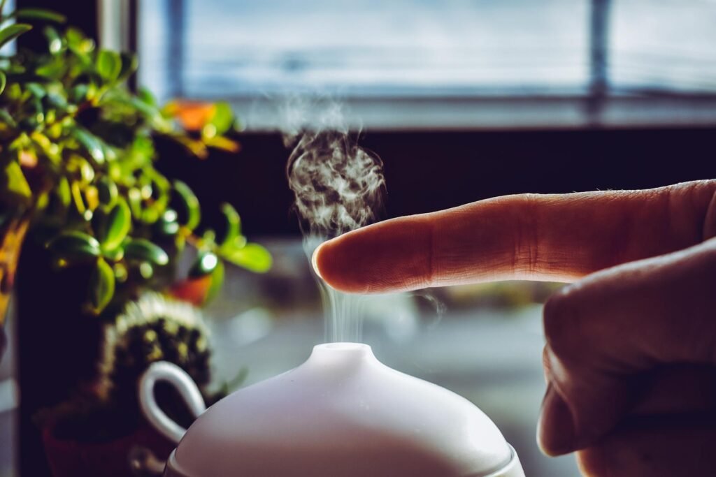 A person touching the mist rising from a humidifier with their finger.